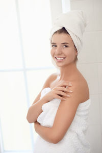 Smiling young woman in bathroom at home