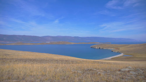 Scenic view of land and mountains against blue sky