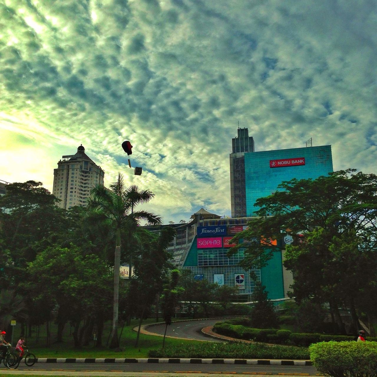 sky, building exterior, architecture, tree, built structure, cloud - sky, cloudy, cloud, city, low angle view, transportation, road sign, growth, communication, day, street light, incidental people, outdoors, overcast, street