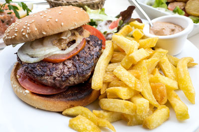 Close-up of hamburger and fries in plate on table