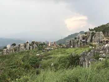 Old ruins on mountain against cloudy sky