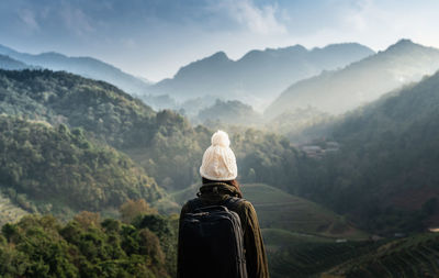 Rear view of woman against mountain range and sky