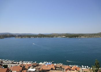 High angle view of sea and buildings against clear sky