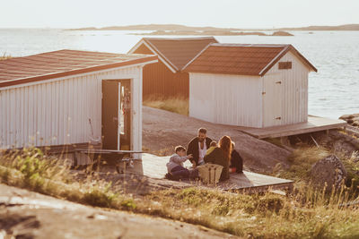 People sitting on beach by house
