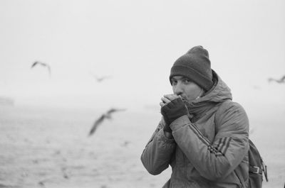 Portrait of young man standing on the seashore 