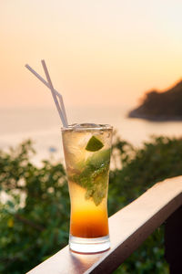 Close-up of drink on table at sunset