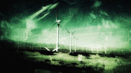 Windmills on grass at night