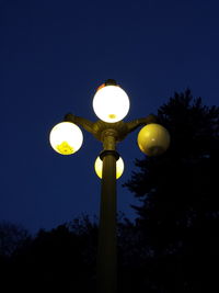 Low angle view of illuminated street light against sky