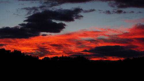 Scenic view of dramatic sky over silhouette landscape