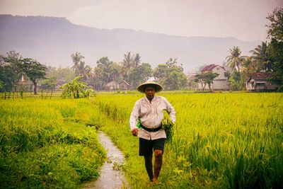 Full length of farmer working in farm