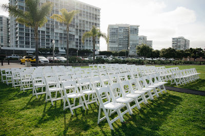 Multiple white folding chairs for event. outdoor city wedding.