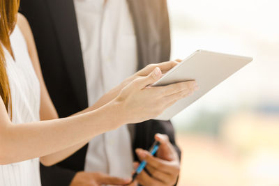 Midsection of woman holding smart phone