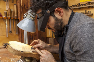 Side view of carpenter working in factory