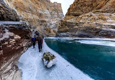 People on rock by water