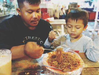 High angle view of boy looking at food on table