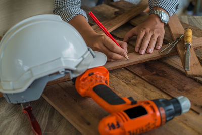 Close-up of carpenter working on workbench in carpentry workshop