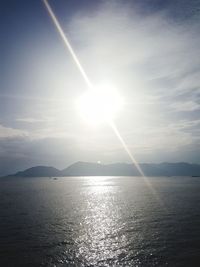 Scenic view of sea against bright sun