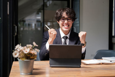 Businesswoman using laptop while sitting on table