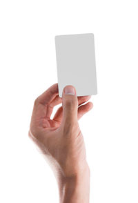 Close-up of hand holding cup against white background