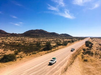 Car on road by land against sky