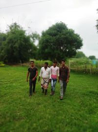 Rear view of people walking on field