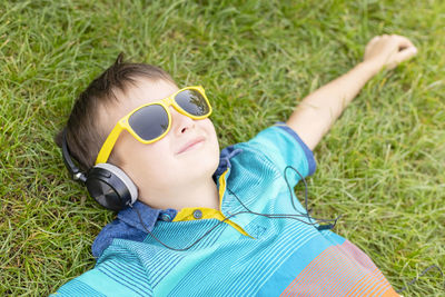 Portrait of young woman wearing sunglasses while standing on grassy field