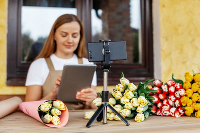 Close-up of the phone on which the florist girl takes a video for her blog of the workflow 