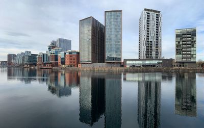 Reflection of buildings in lake against sky