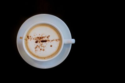 Directly above shot of coffee cup against black background