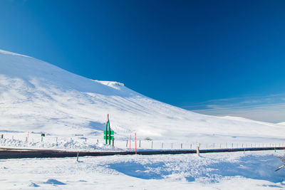 Scenic view of snowcapped mountains against blue sky