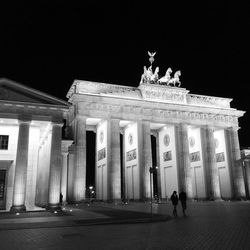 Statue in city at night