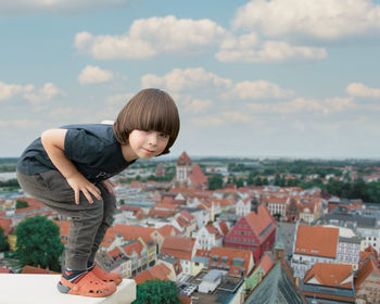 Side view of boy looking at cityscape