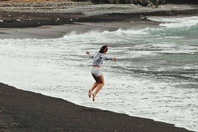 Woman jumping at beach