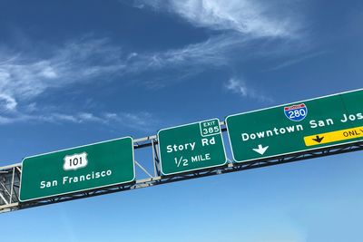 Low angle view of road sign against sky