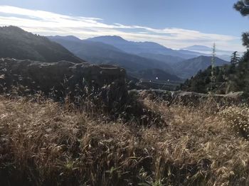 Scenic view of land and mountains against sky