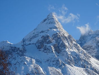 Scenic view of snowcapped mountains against blue sky