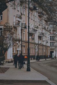 Rear view of people walking on street amidst buildings