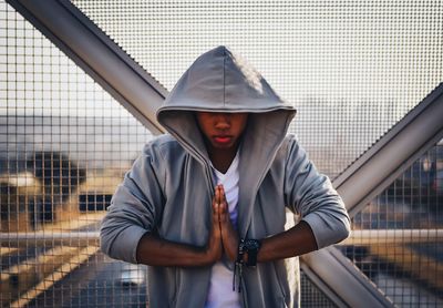 Portrait of young man standing against wall