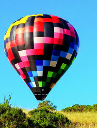 Low angle view of hot air balloons against clear blue sky