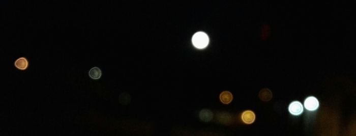 Low angle view of illuminated moon against sky at night