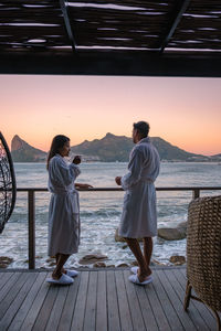 Rear view of couple standing at beach