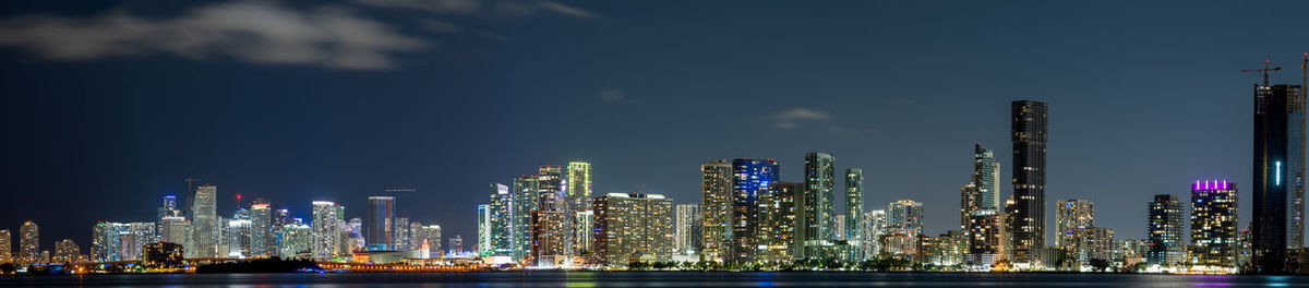 Illuminated cityscape against sky at night