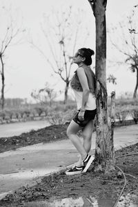 Full length of woman standing by tree