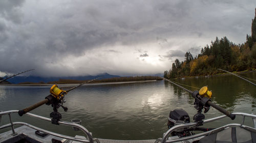 People sailing on river against sky