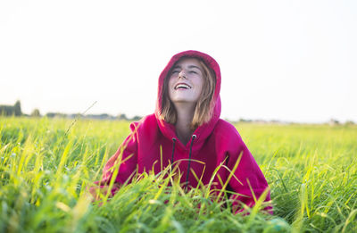 Portrait of young woman sitting on grassy field