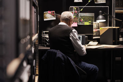 Side view of woman using mobile phone in library