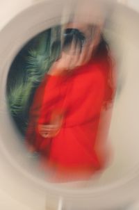 Reflection of woman in red mirror