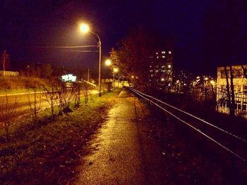 Railroad tracks against sky at night