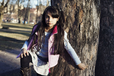 Full length of woman standing on tree trunk