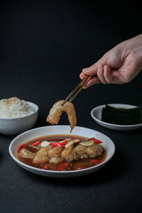 Cropped hand of person preparing food on table